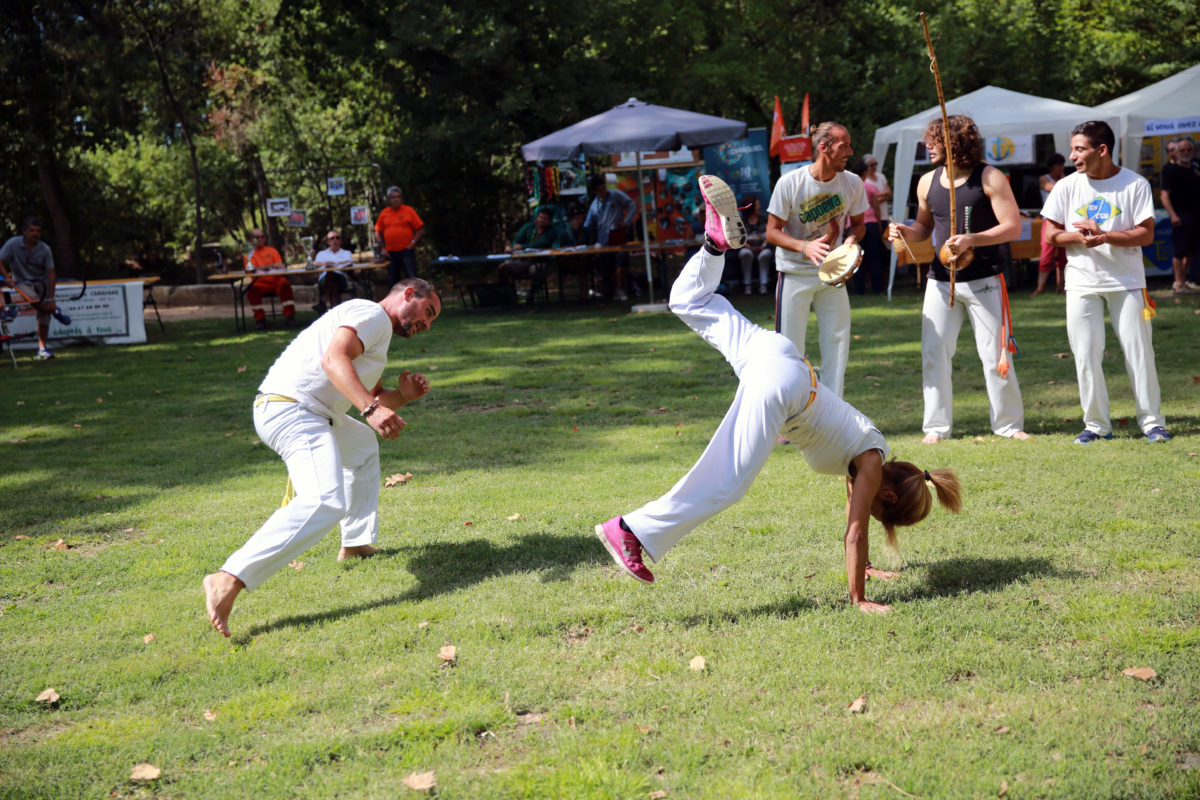 menino menina jogando capoeira berimbau