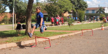 menino pula obstáculos em pista de terra