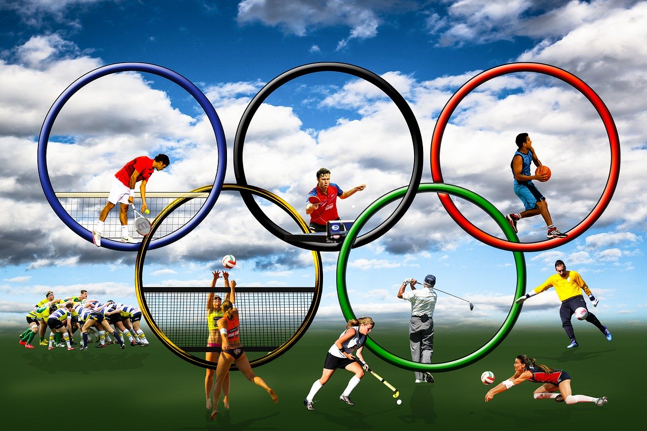 imagem mostra aros Olímpicos com vários atletas praticando diferentes esportes dentro deles