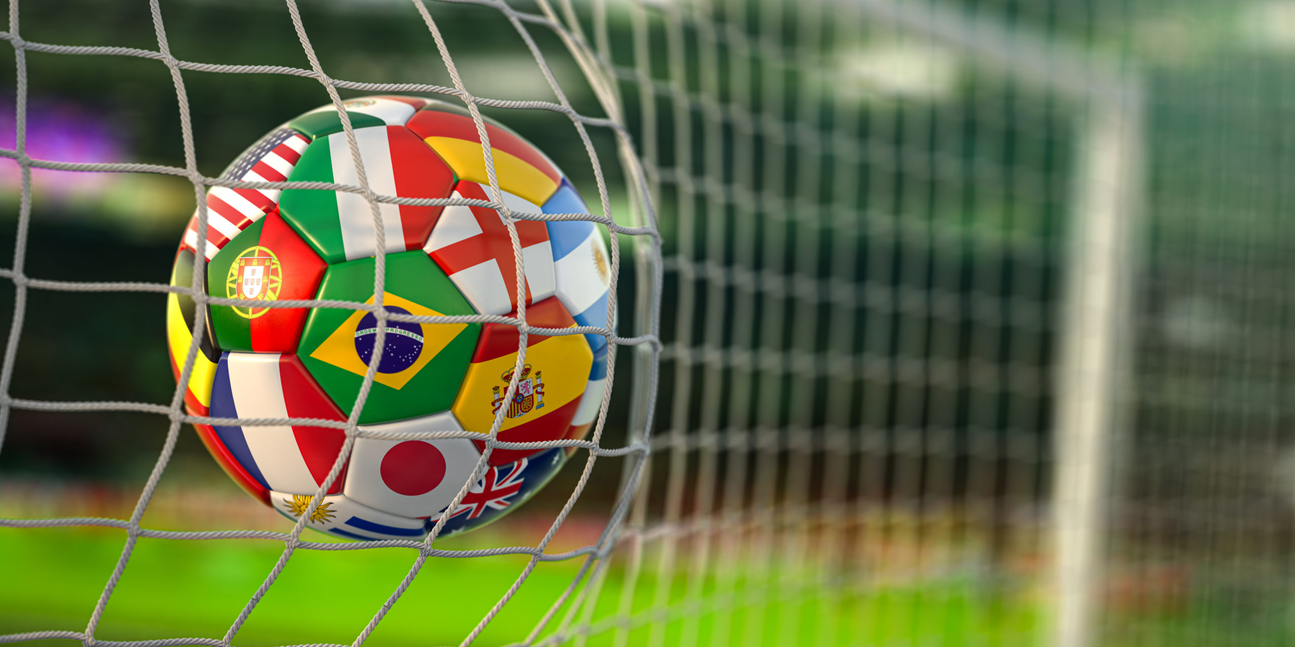 bola de futebol estampada com várias bandeiras de seleções (Brasil, Espanha, Argentina, etc) tocando a rede do gol