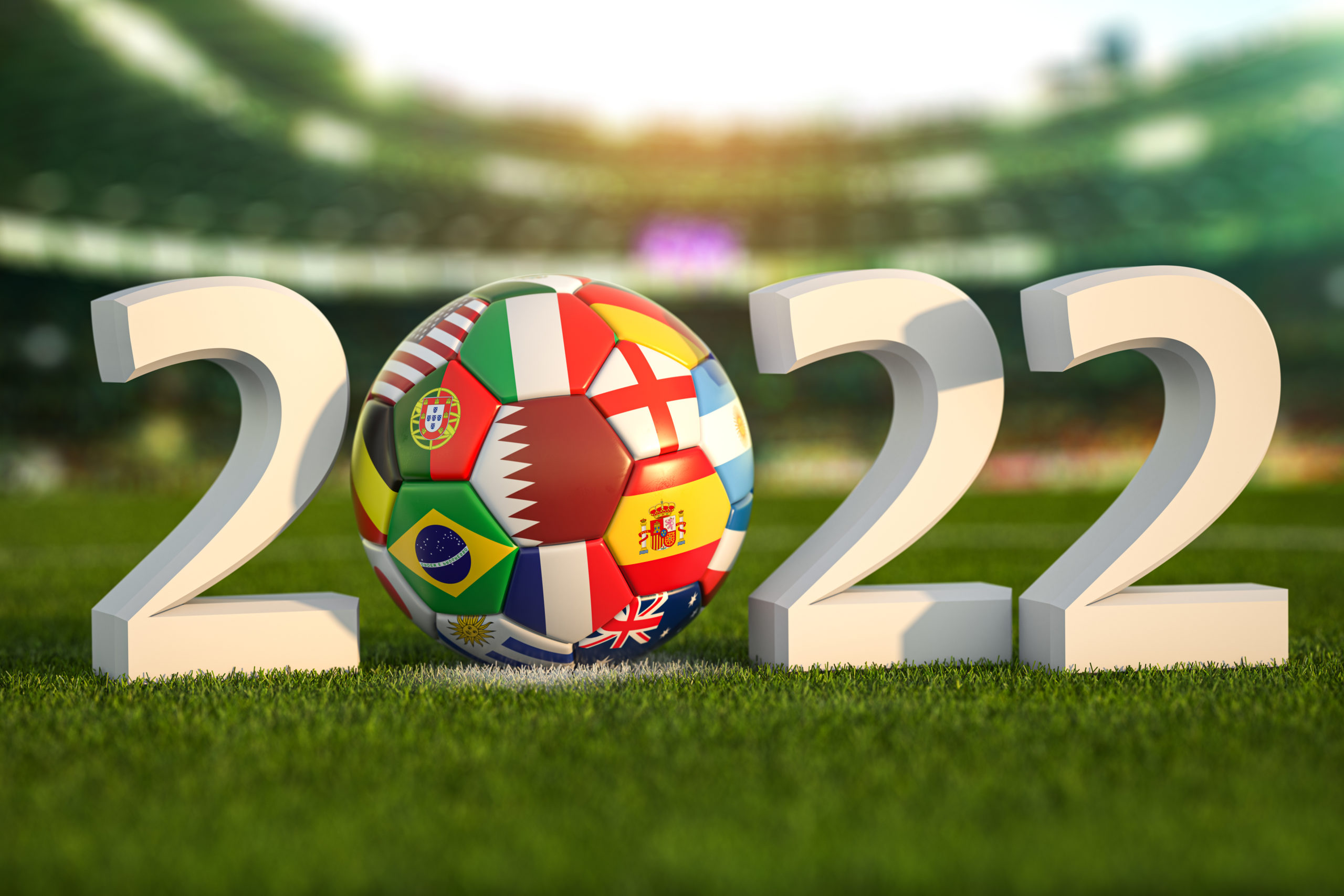 Ano de 2022 no campo de um estádio com uma bola estampada com a bandeira de algumas seleções participantes da Copa do Mundo de 2022 no Catar como Brasil, Argentina e Espanha.