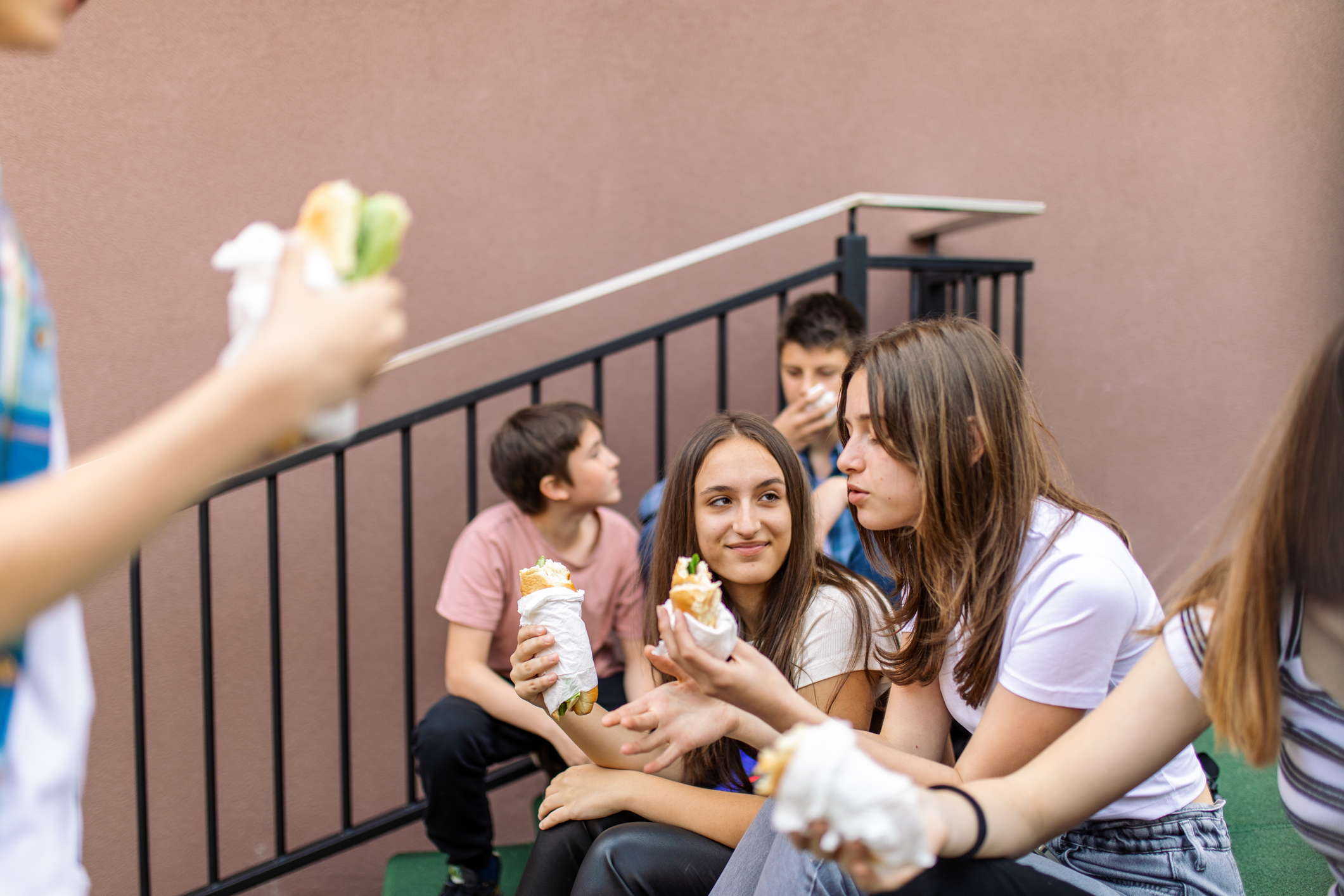 adolescentes se alimentando de sanduíche na escola